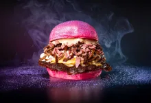 Bright Pink Burger with Bacon Melted Cheese and Crispy Toppings on a Pink Bun Against a Dark Background with Purple Dusting La Hamburguesa Zaragozana Que Triunfa En the Champions Burger Zaragozala   Qué Hacer En Zaragoza
