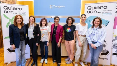 Seven women pose for a photo at an indoor Zaragoza event, with 'Quiero ser...' banners on both sides and a blue Zaragoza backdrop behind them.