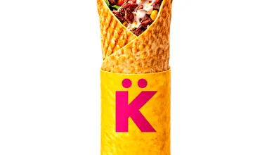 Beef-filled wrap upright in a yellow wrapper with a pink K logo.
