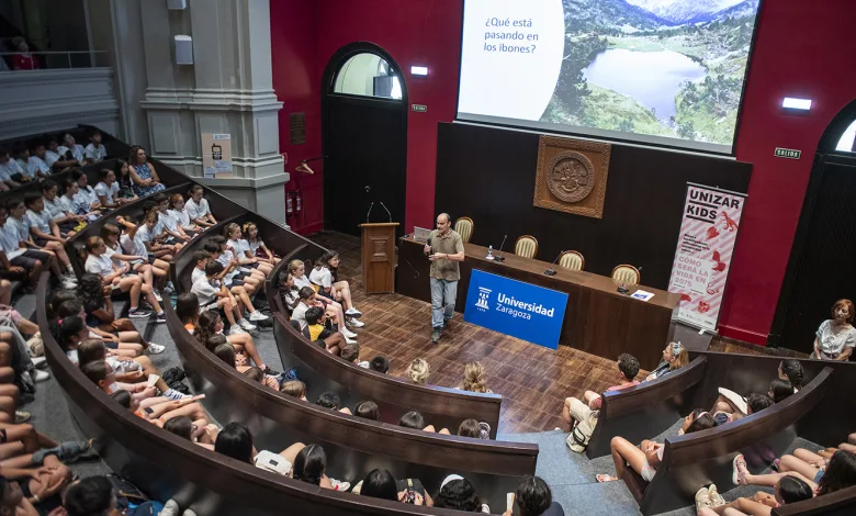Speaker at a Podium Addressing a Large Student Audience in a Curved Tiered University Auditorium for a Lecture Unizar Kids 2026 Abordará El Eclipse Solar La Ia Y El Futuro Del Planeta Con Escolares De Aragón Zaragozala Qué Hacer En Zaragoza