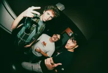 Three Young Men at a Dim Club Pose for the Camera the Foreground Man Flinks a Peace Sign and Holds a Bottle Zaragoza Qué Hacer En Zaragoza Zaragozala Qué Hacer En Zaragoza