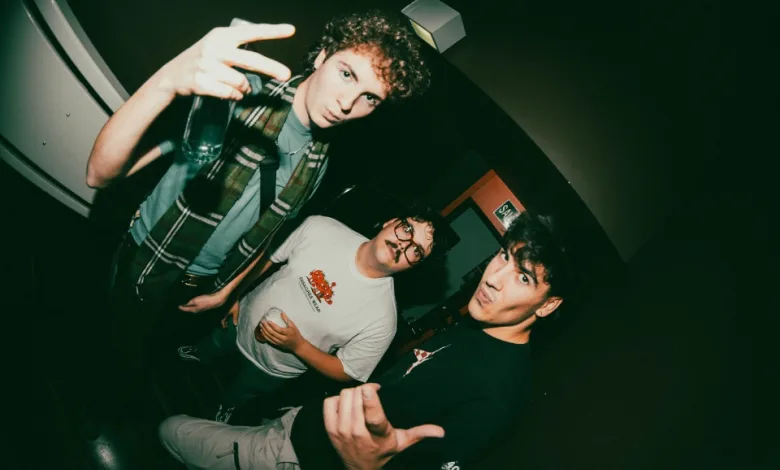 Three Young Men at a Dim Club Pose for the Camera the Foreground Man Flinks a Peace Sign and Holds a Bottle Zaragoza Qué Hacer En Zaragoza Zaragozala Qué Hacer En Zaragoza