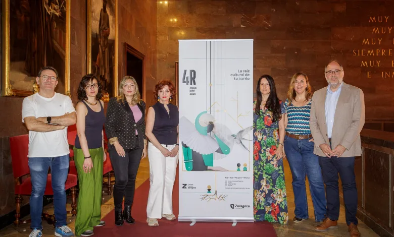 Eight Adults Stand on a Red Carpet Beside a Tall Promotional Banner for an Event 4r Mayjuly 2026 in a Marble walled Venue Programa 4r Zaragoza Actividades Gratuitas En Los Barrios Rurales Zaragozala Qué Hacer En Zaragoza