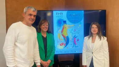 Four Adults Posing Indoors Beside a Tall Screen Displaying a Blue Poster for a Fairy tale Festival with a Dragon Illustration Anento Se Llena De Fantasía Con Érase Una Vez Anento Zaragozala Qué Hacer En Zaragoza