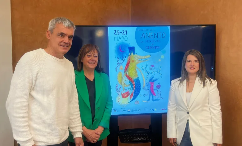 Four Adults Posing Indoors Beside a Tall Screen Displaying a Blue Poster for a Fairy tale Festival with a Dragon Illustration Anento Se Llena De Fantasía Con Érase Una Vez Anento Zaragozala Qué Hacer En Zaragoza