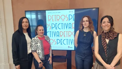 Four Women Pose Together Indoors in Front of a Display Screen with a Blue Poster Banner Quinto Vuelve a Llenar Sus Calles De Carteles Vintage Con La Iv Edición De retrospectiva Zaragozala   Qué Hacer En Zaragoza