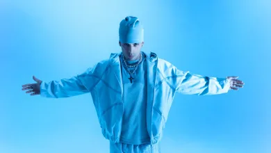 Person in All blue Outfit tank Top Jacket Beanie with Arms Outstretched Against a Blue Background Bold Fashion Pose Zaragoza   Qué Hacer En Zaragoza Zaragozala   Qué Hacer En Zaragoza
