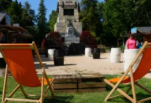 Park Scene with a Stone Monument Surrounded by Red Flowers Orange Lounge Chairs and a Wooden Pallet Seating Area in the Foreground Zaragoza Qué Hacer En Zaragoza Zaragozala Qué Hacer En Zaragoza