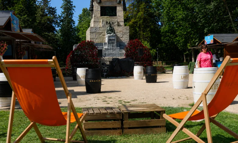 Park Scene with a Stone Monument Surrounded by Red Flowers Orange Lounge Chairs and a Wooden Pallet Seating Area in the Foreground Así Es La Placita El Nuevo Espacio De Zaragoza Florece 2026 Zaragozala   Qué Hacer En Zaragoza