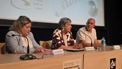 Panel Discussion with Three Speakers at a Table Left Woman Writes Middle Woman Speaks Right Man Listens Microphones in Front El Trabajo Social Reclama En Zaragoza Su Reconocimiento Oficial Como Profesión Sanitaria Zaragozala Qué Hacer En Zaragoza