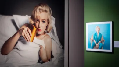 Large Photo of a Blonde Woman in a White Shirt Lying in Bed Holding an Orange Bottle with Framed Art on a Green Wall Beside Exposición De Marilyn Monroe En El Centro De Historias Zaragozala   Qué Hacer En Zaragoza