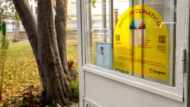 Yellow Climate Refuge Poster on a Glass Door with Text refugio ClimÁtico and a Color Wheel Located in a Small Booth by Trees Outside Zaragoza Activa Su Red De Refugios Climáticos Con Más De 60 Espacios Municipales Frente Al Calor Zaragozala Qué Hacer En Zaragoza