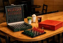 Open Green Chess Set on a Wooden Table with Red and Green Pieces a Red Case Sits Nearby and Three Starbucks Drinks Line Up Behind Them Zaragozala | Agenda Cultural Ocio Y Planes En Zaragoza Zaragozala Qué Hacer En Zaragoza