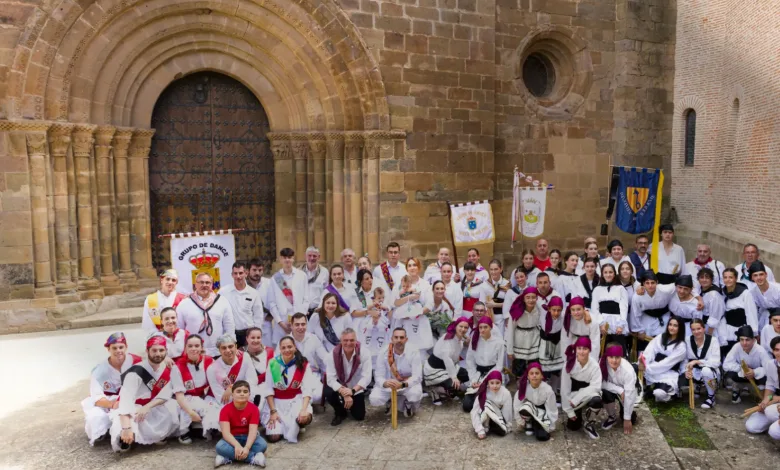 Group of Dancers in White Traditional Costumes with Red Sashes Pose in Front of a Historic Stone Building with Arches and Banners Nearby Veruela Reúne Los Dances Del Moncayo En Veruela Estival Zaragozala   Qué Hacer En Zaragoza