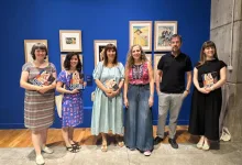 Six Adults Pose in an Art Gallery Against a Blue Wall Each Holding a Book with Framed Pictures Visible Behind Them on the Wall Zaragozala | Agenda Cultural Ocio Y Planes En Zaragoza Zaragozala   Qué Hacer En Zaragoza