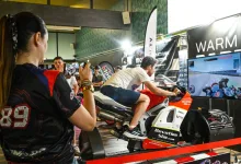 Person Rides a Red and white Racing Motorcycle on a Simulator at an Indoor Expo While a Crowd Watches and Records with a Phone Zaragozala | Agenda Cultural Ocio Y Planes En Zaragoza Zaragozala   Qué Hacer En Zaragoza