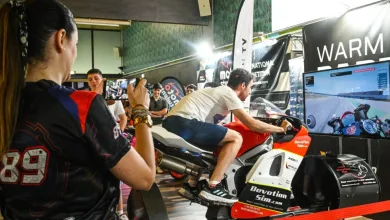Person Rides a Red and white Racing Motorcycle on a Simulator at an Indoor Expo While a Crowd Watches and Records with a Phone La Warm Up Party De Motorland Vive Este Domingo Su Gran Jornada Zaragozala   Qué Hacer En Zaragoza