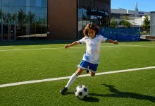Child Soccer Player Kicking a Black and white Ball on Bright Artificial Turf with Modern Buildings in the Background Zaragozala | Agenda Cultural Ocio Y Planes En Zaragoza Zaragozala   Qué Hacer En Zaragoza