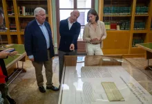 Three Adults Gather Around a Glass Display Case in a Library Examining a Large Document Zaragozala | Agenda Cultural Ocio Y Planes En Zaragoza Zaragozala   Qué Hacer En Zaragoza