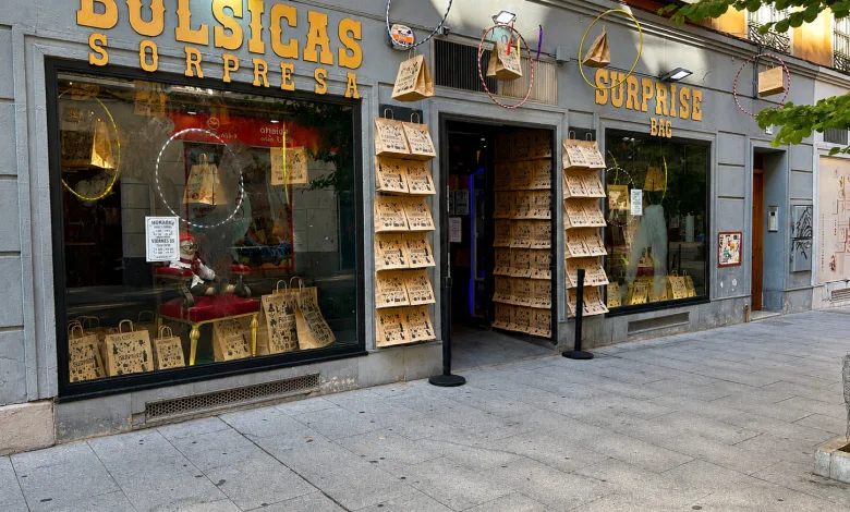 Shopfront with Large Yellow Signage Reading surprise Bag and bolsicas Sorresa store Selling Mystery Bags Brown Paper Bags Hung Outside and in Windows and Display Windows Showing Merchandise Zaragoza Estrena Tienda De Bolsicas Sorpresa Desde 8 Euros Zaragozala   Qué Hacer En Zaragoza