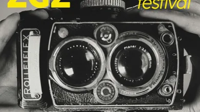 Poster for Summer Foto Zgz Festival in Zaragoza Featuring a Vintage Camera and Bold Yellow Typography Diagonal Pink Band Lists Dates and Events Mmer Foto Zgz 2026 Reúne En Zaragoza a Isabel Muñoz Zaragozala   Qué Hacer En Zaragoza