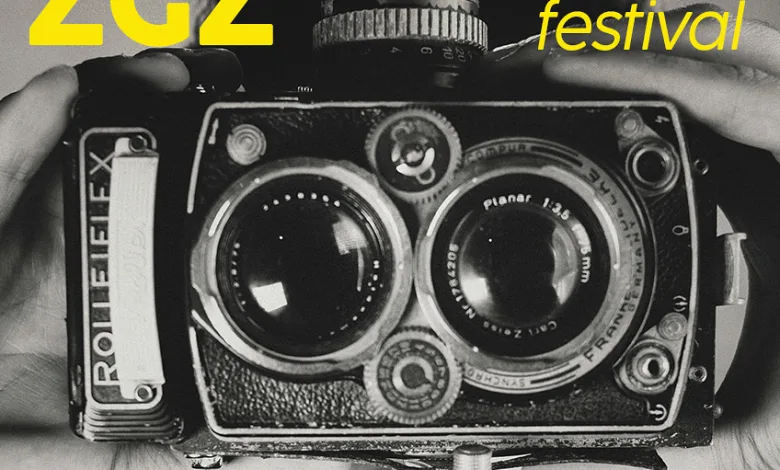 Poster for Summer Foto Zgz Festival in Zaragoza Featuring a Vintage Camera and Bold Yellow Typography Diagonal Pink Band Lists Dates and Events Mmer Foto Zgz 2026 Reúne En Zaragoza a Isabel Muñoz Zaragozala   Qué Hacer En Zaragoza