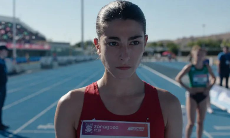 Female Athlete at Starting Line on a Blue Track Focused Wearing a Red Racing Singlet with a Zaragoza 2025 Bib Number Pase Especial De Corredora Con Coloquio En Los Cines Palafox Zaragozala Qué Hacer En Zaragoza