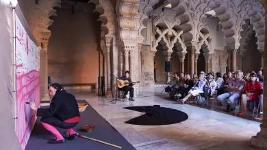 Guitarist Seated on Stage Playing a Guitar in a Historic Arched Hall with an Audience Seated and Watching a Performance La Aljafería Revive El Universo De Goya Con Una Performance Inmersiva De Samuel Hereza Jorge Casasnovas Y Alek Mir Zaragozala Qué Hacer En Zaragoza