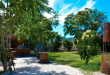 Sunny Outdoor Garden with Tall Trees a Paved Path a Wooden Spool Table and a Rust Sculpture on the Lawn to the Right Under a Blue Sky Zaragozala | Agenda Cultural Ocio Y Planes En Zaragoza Zaragozala Qué Hacer En Zaragoza