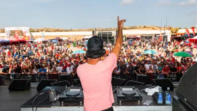 Dj on Stage with Pink Shirt Raises Right Arm to Cheering Crowd at a Large Outdoor Festival Mixing Gear in Front of Him Zaragoza Acoge La Fiesta De Motogp Los Días 27 Y 28 De Junio Zaragozala Qué Hacer En Zaragoza