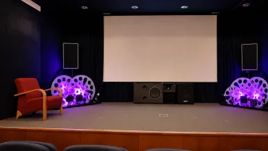 Stage Setup in a Small Theater Large Blank Screen Center Purple lit Speakers and Decorative Circular Props on Both Sides and a Red Armchair on the Left Zaragozala | Agenda Cultural Ocio Y Planes En Zaragoza Zaragozala   Qué Hacer En Zaragoza