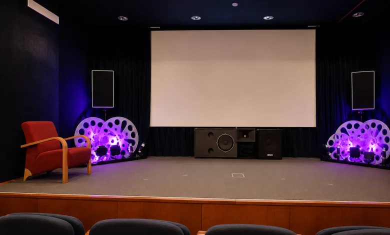 Stage Setup in a Small Theater Large Blank Screen Center Purple lit Speakers and Decorative Circular Props on Both Sides and a Red Armchair on the Left Zaragozala | Agenda Cultural Ocio Y Planes En Zaragoza Zaragozala   Qué Hacer En Zaragoza
