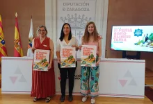 Three Women Stand Side by Side Each Holding a Brochure for a Regional Fair in a Formal Presentation Room with Flags and a Screen to the Right Zaragozala | Agenda Cultural Ocio Y Planes En Zaragoza Página 1022 Zaragozala Qué Hacer En Zaragoza