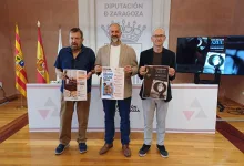 Three Men Stand Holding Event Posters in Front of a Zaragoza Diputación Backdrop with Flags on the Left Zaragozala | Agenda Cultural Ocio Y Planes En Zaragoza Zaragozala   Qué Hacer En Zaragoza