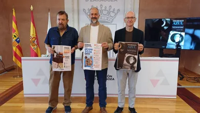 Three Men Stand Holding Event Posters in Front of a Zaragoza Diputación Backdrop with Flags on the Left Zaragozala | Agenda Cultural Ocio Y Planes En Zaragoza Zaragozala   Qué Hacer En Zaragoza
