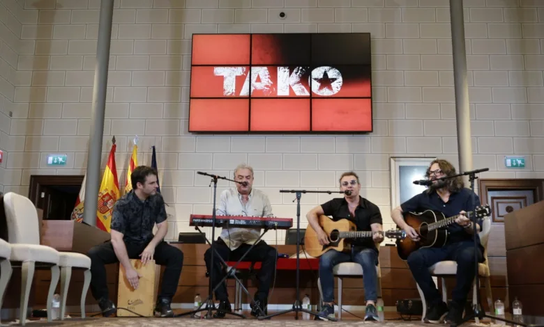 Four Musicians Perform on a Stage Two Guitarists a Keyboard Player and a Percussionist with a Red Tako Screen Behind and Flags Nearby on the Left Tako Gratis En Veruela Cuándo Y Dónde Recoger Invitaciones Zaragozala   Qué Hacer En Zaragoza