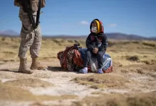 Soldier Standing with Rifle Nearby a Child Sitting on a Blanket in a Desert Landscape Both Wearing Masks Zaragozala | Agenda Cultural Ocio Y Planes En Zaragoza Zaragozala   Qué Hacer En Zaragoza
