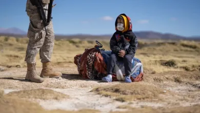 Soldier Standing with Rifle Nearby a Child Sitting on a Blanket in a Desert Landscape Both Wearing Masks Zaragozala | Agenda Cultural Ocio Y Planes En Zaragoza Zaragozala   Qué Hacer En Zaragoza