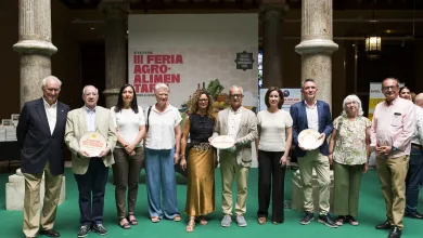 Group of People Posing for a Photo at an Agro food Fair Holding Plates in Front of a Banner Reading iii Feria Agro alimentaria in a Hall with Stone Columns and a Green Carpet Zaragozala | Agenda Cultural Ocio Y Planes En Zaragoza Zaragozala   Qué Hacer En Zaragoza