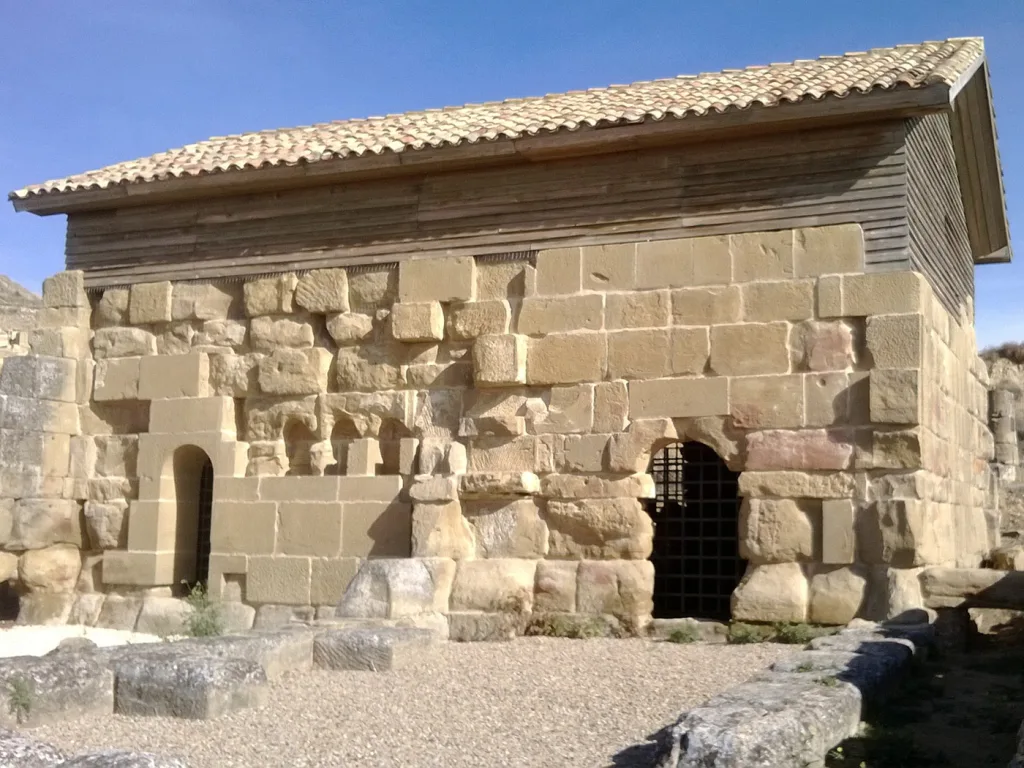 Ancient Stone Ruin with a Two level Wooden Upper Structure an Arched Doorway with a Grate on a Sunny Day Under a Blue Sky Los Bañales La Ciudad Romana Cerca De Zaragoza Zaragozala Qué Hacer En Zaragoza