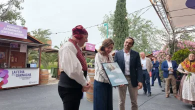 Woman in Traditional Dress Receives a Framed Certificate from Two Men at a Wine Festival with String Lights and Stalls in the Background Zaragozala | Agenda Cultural Ocio Y Planes En Zaragoza Zaragozala   Qué Hacer En Zaragoza