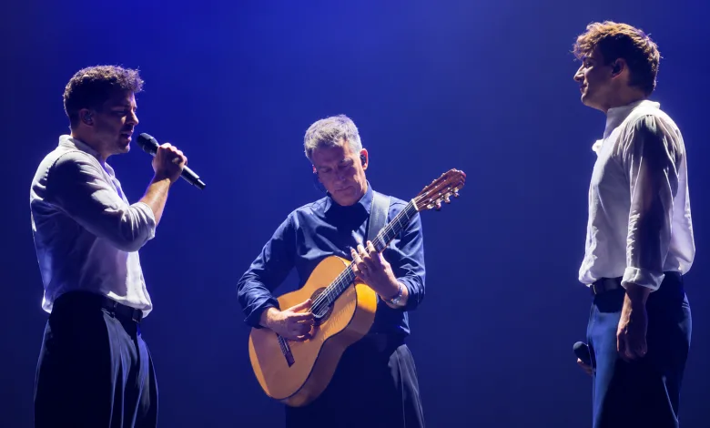 Three Male Musicians Perform on Stage One Sings with a Microphone the Center Guitarist Plays an Acoustic Guitar Under Blue Stage Lighting Zaragozala | Agenda Cultural Ocio Y Planes En Zaragoza Zaragozala Qué Hacer En Zaragoza