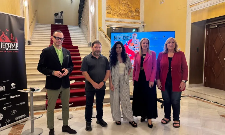 Five Adults Stand Together in a Marble Lobby with a Red carpet Staircase Behind Them a Moviecamp Banner on the Left and a Large Display Screen in the Back Moviecamp Sos 2026 Amplía Plazas Y Contará Con Pilar Palomero Andrea Fandos Y Jorge Asín Zaragozala Qué Hacer En Zaragoza