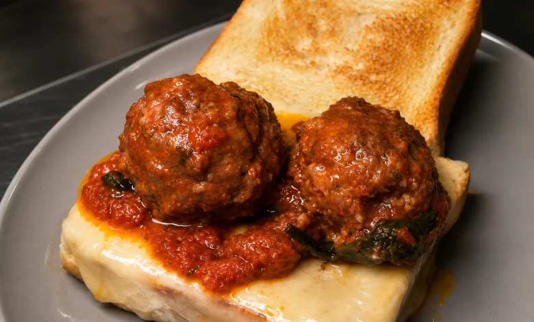 Two Meatballs in Tomato Sauce Resting on Melted Cheese Atop a Slice of Toasted Bread with a Second Toasted Slice on the Plate Los Auténticos Sándwiches De Nueva York Aterrizan En Zaragoza Zaragozala Qué Hacer En Zaragoza