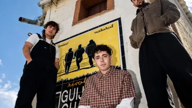 Three Young Men Pose in Front of a Bright Yellow Mural on a Weathered White Building Under a Blue Sky Conciertos Agotados En Pirineos Sur 2026 Y últimas Entradas Zaragozala Qué Hacer En Zaragoza