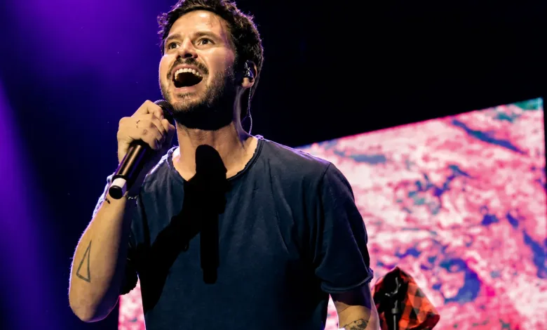 Male Singer on Stage Gripping a Microphone Under Purple Lights Mid performance Espacio Zity 2026 Taburete Álvaro De Luna Y Hey Kid Zaragozala   Qué Hacer En Zaragoza