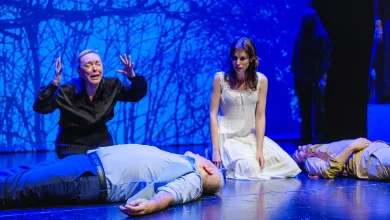 Two Actors on a Blue lit Stage Kneel Beside Motionless Bodies As a Woman in Black Gestures Dramatically While a Woman in a White Dress Looks On Zaragozala | Agenda Cultural Ocio Y Planes En Zaragoza Zaragozala   Qué Hacer En Zaragoza