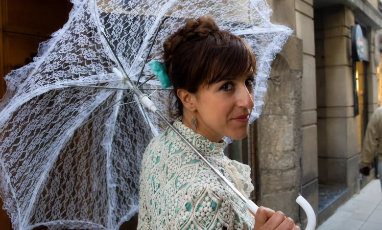 Woman in a Light Green Lace Blouse Holding a Delicate White Lace Umbrella on a City Sidewalk Smiling Slightly Toward the Camera Zaragozala | Agenda Cultural Ocio Y Planes En Zaragoza Zaragozala   Qué Hacer En Zaragoza