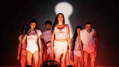 a Group of Dancers in White Outfits Standing on Stage Under Red Lighting with a Large Bright Spotlight Behind Them Judeline Samuraï Y Elem Toman Pirineos Sur 2026 Zaragozala Qué Hacer En Zaragoza