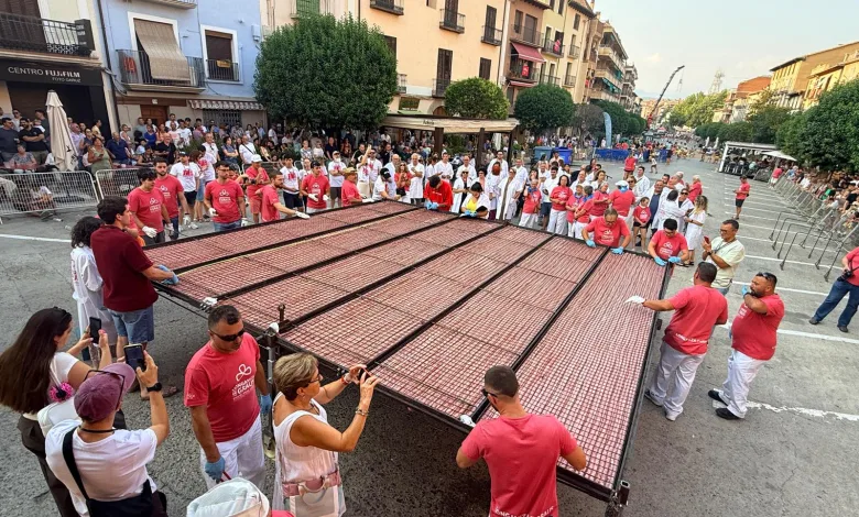 Large Street Festival with a Giant Outdoor Grill and Dozens of People in Red Shirts Tending the Grid Pit While Spectators Line the Sidewalks Longaniza De Graus Alcanza 915 Metros Y Bate Récord Zaragozala Qué Hacer En Zaragoza